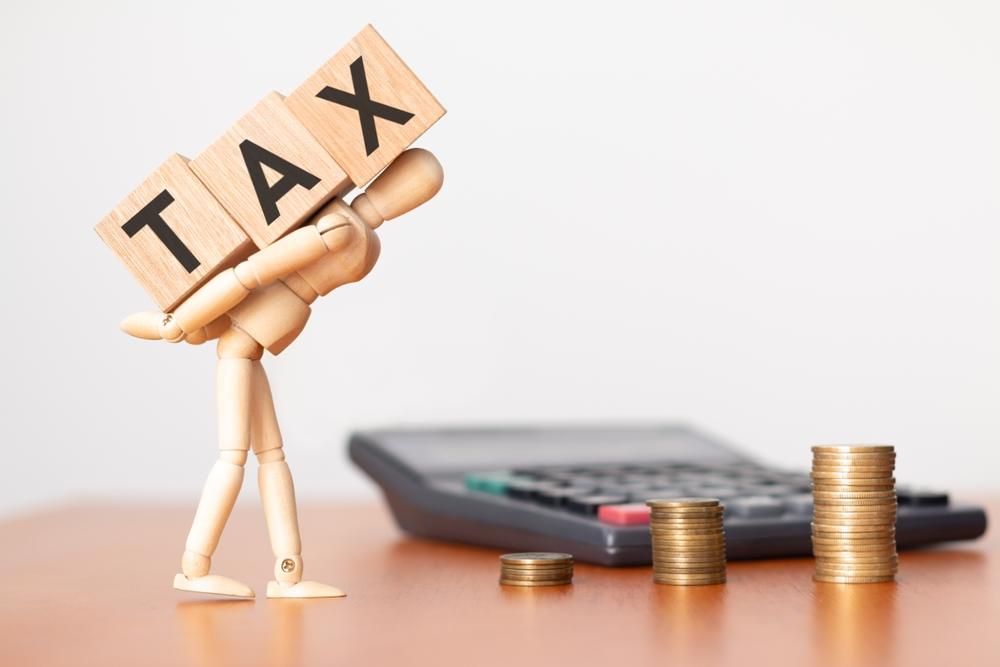 A wooden figure carries the word “Tax” on its back to symbolize the question of whether disability benefits are taxable.