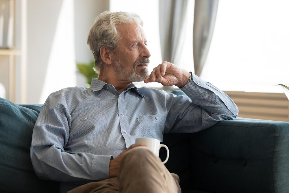A man sitting on his couch, wondering what happens to life insurance when you leave a job.