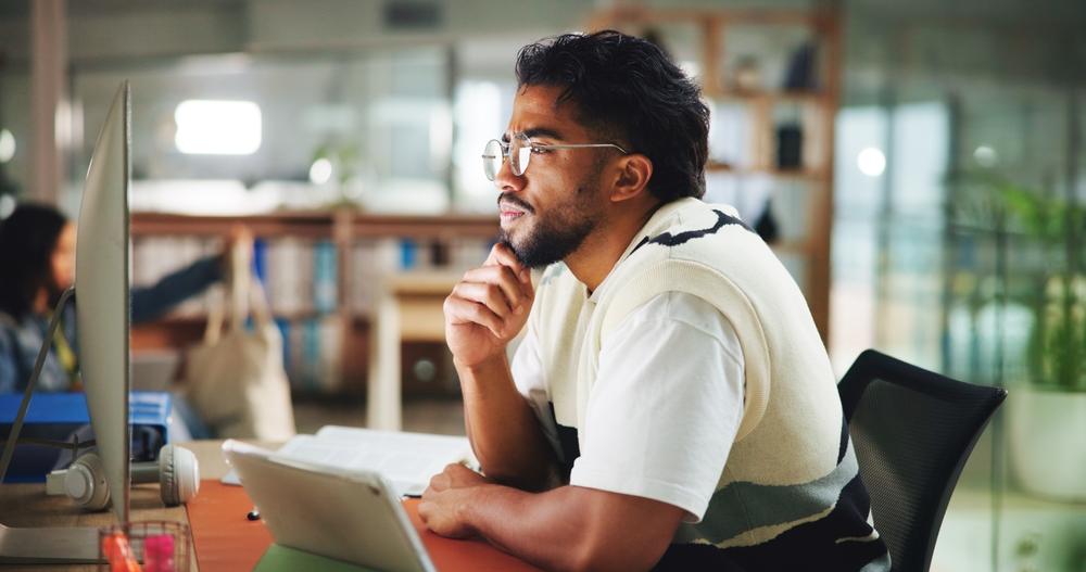 A man sitting at a computer, wondering if he needs long-term disability insurance in Baton Rouge.