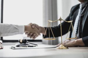 attorney and client shaking hands across desk